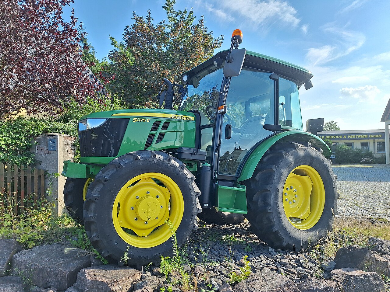 John Deere 5075E visad utomhus vid en återförsäljare i Münchenbernsdorf.