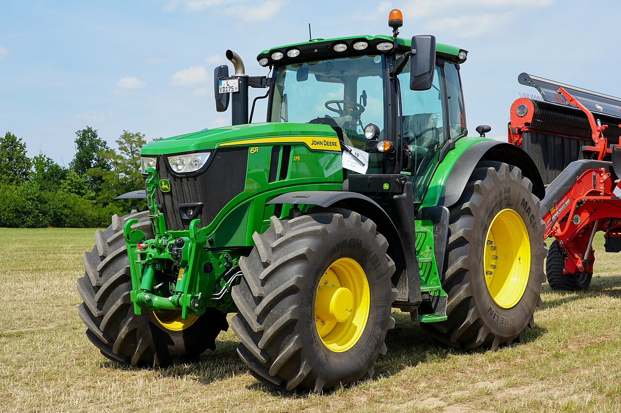 John Deere 6R 175 med ett Kuhn Merge Maxx 1090-redskap vid en maskinvisning.
