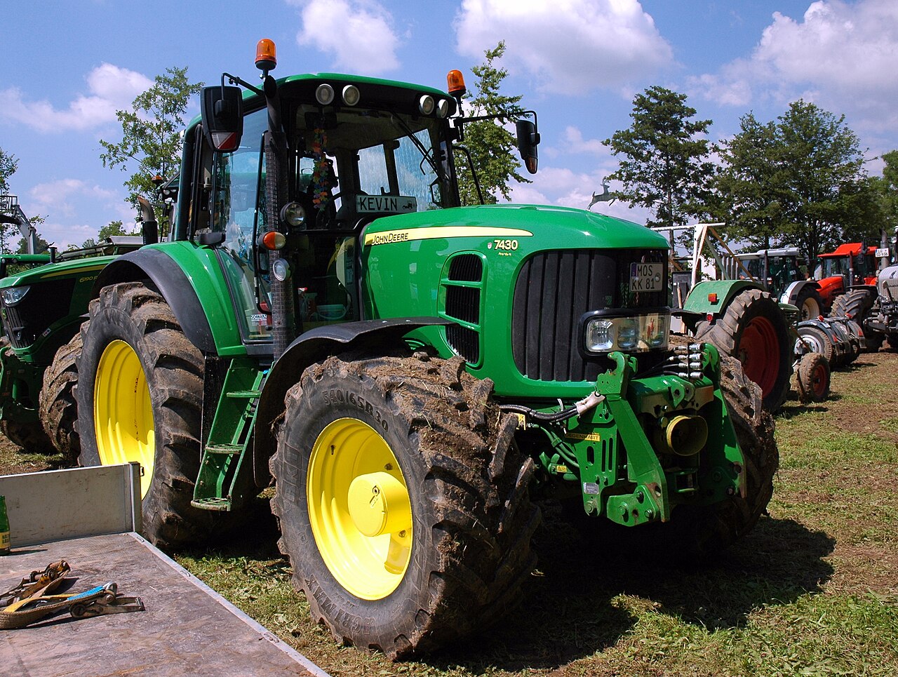 John Deere 7430 Premium på en utomhusvisning, fotograferad framifrån från sidan.