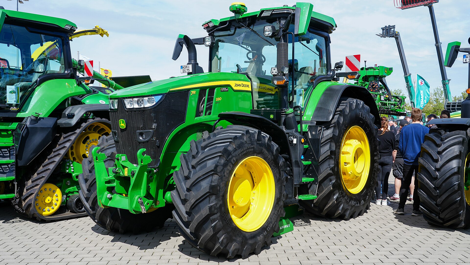 John Deere 7R 330 med synlig Gen 2-märkning, fotograferad snett framifrån på agra 2024.