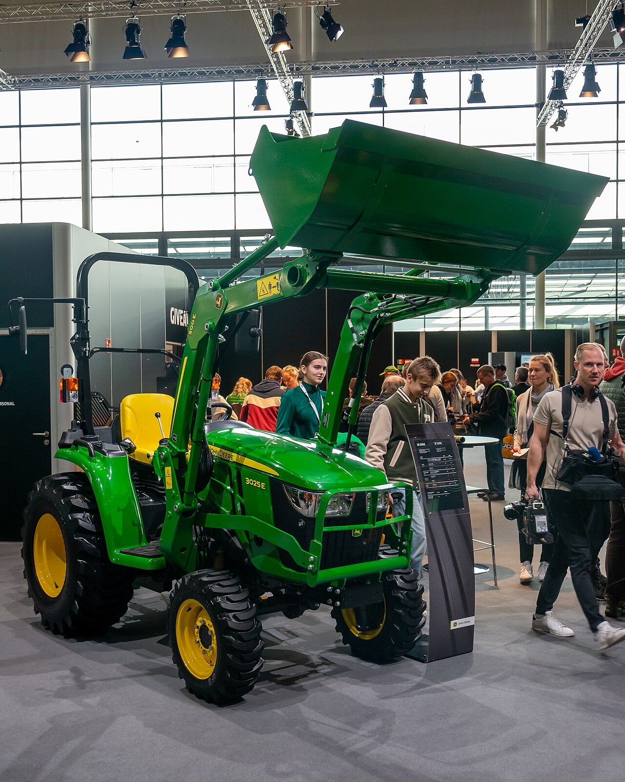 Grön John Deere 3025 E kompakttraktor med frontlastare på Agritechnica 2023.