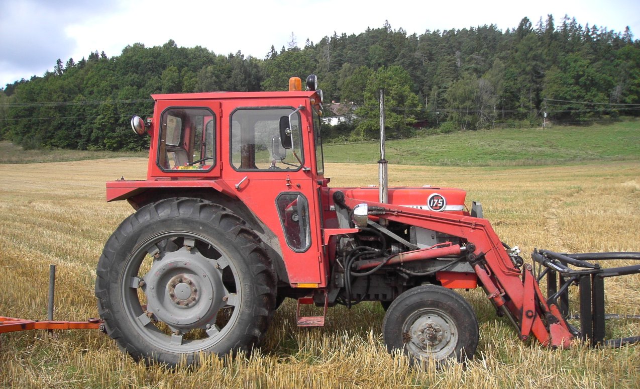 Röd Massey Ferguson 175 med frontlastare i ett skördefält; 175-emblemet syns på motorhuven.