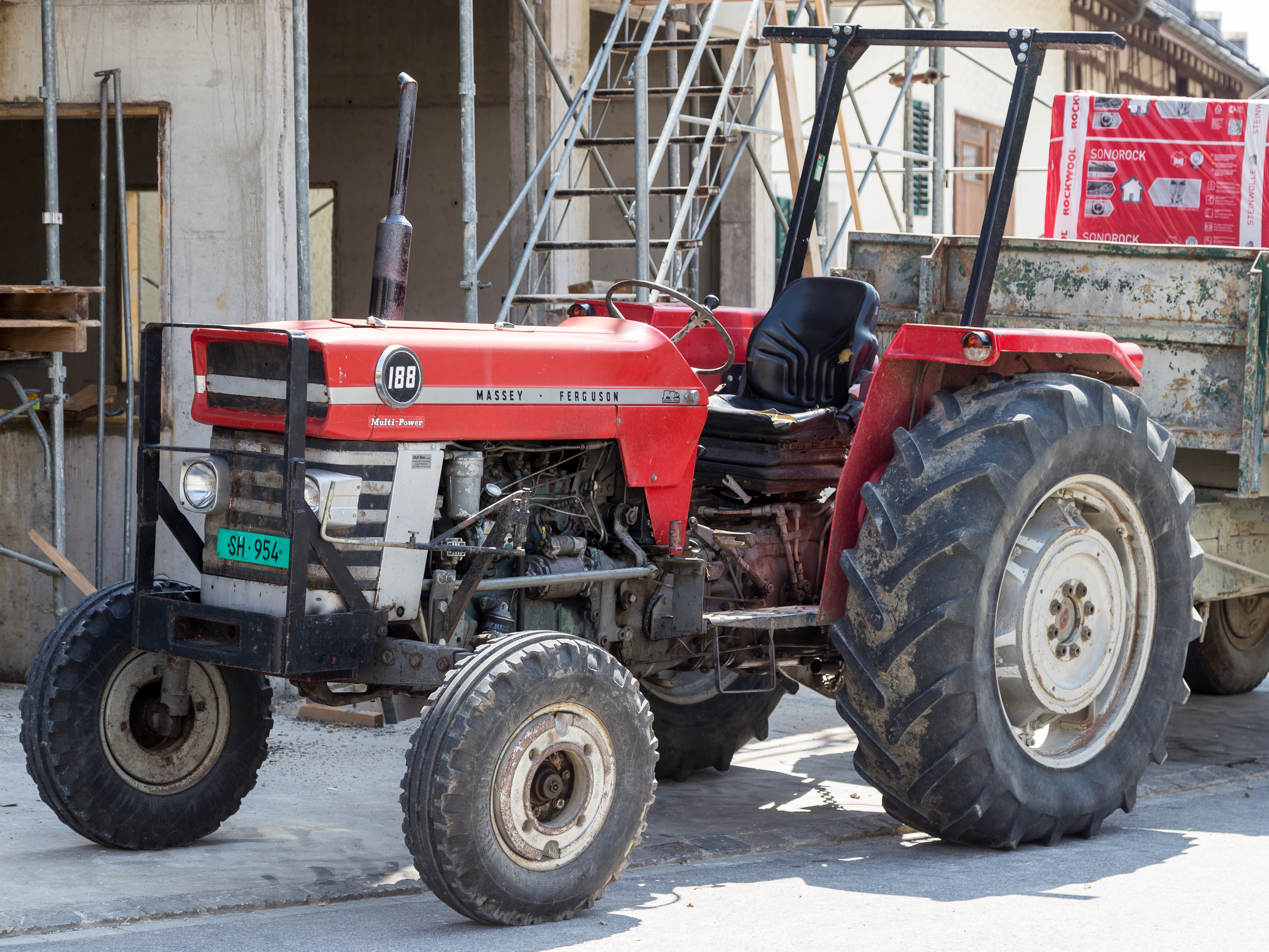 Komplett röd Massey Ferguson MF 188 med synliga 188- och Multi-Power-märken, fotograferad utomhus i Schweiz; traktorn har öppen, hyttlös förarplats.