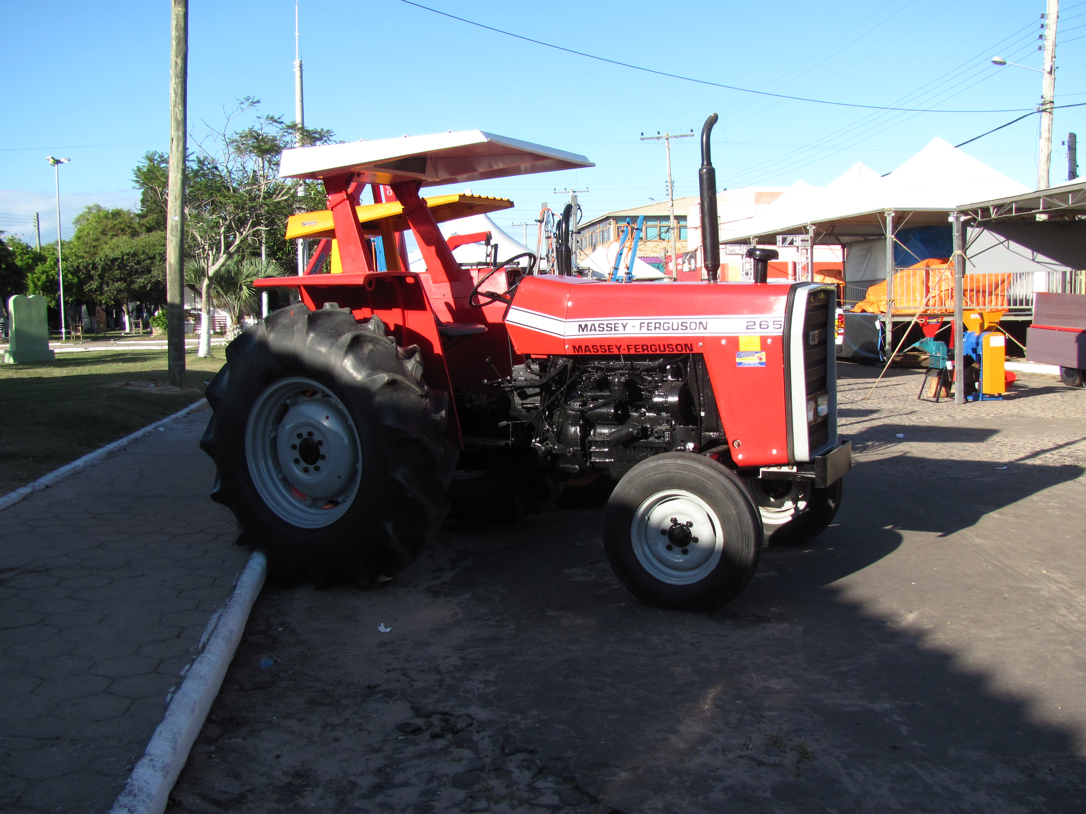 Röd Massey Ferguson 265 med synlig sidomärkning, fotograferad vid en lantbruksutrustningsmässa i Tavares i Brasilien.