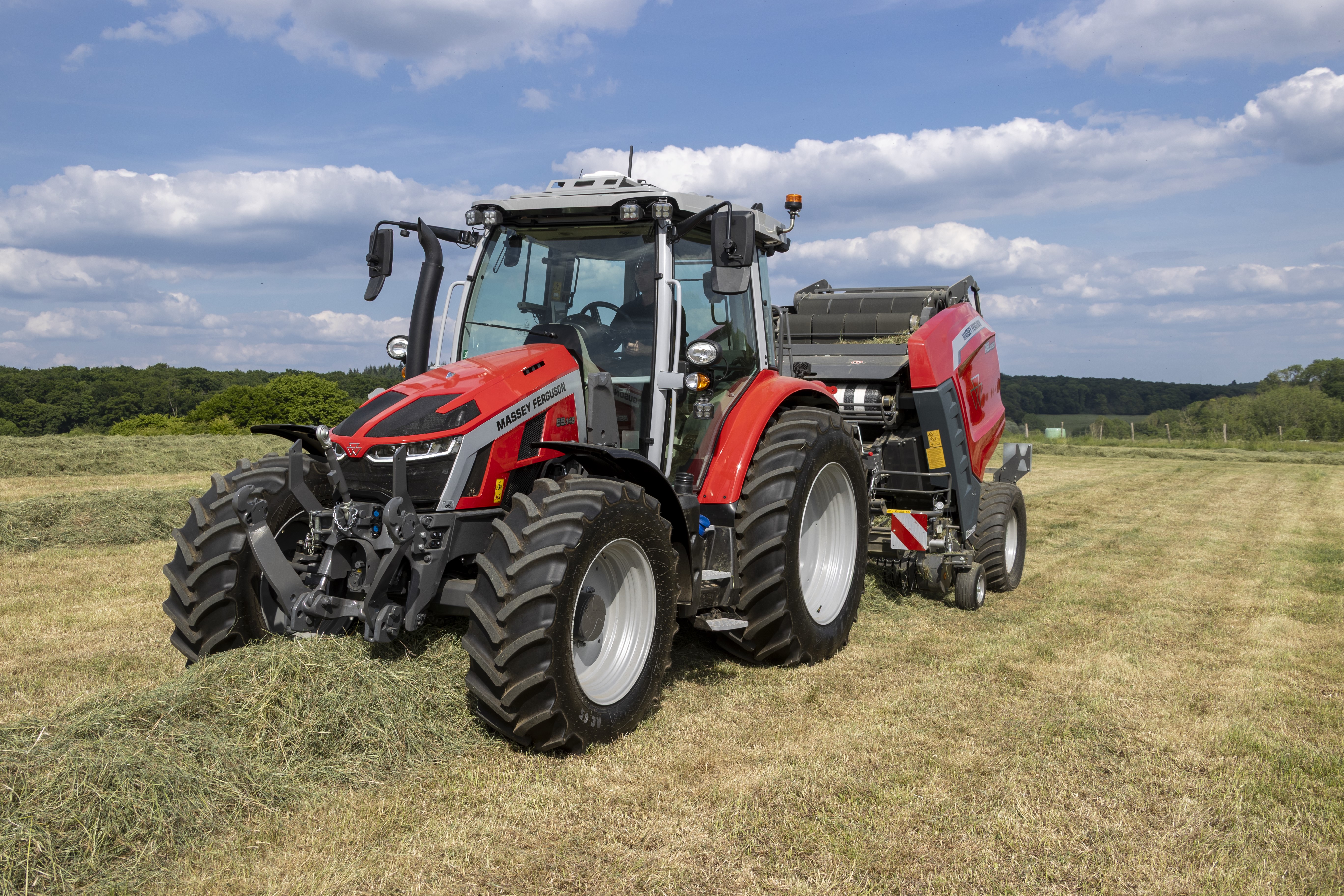 Massey Ferguson 5S.145 Dyna-VT med rundbalspress vid balning på ett fält.