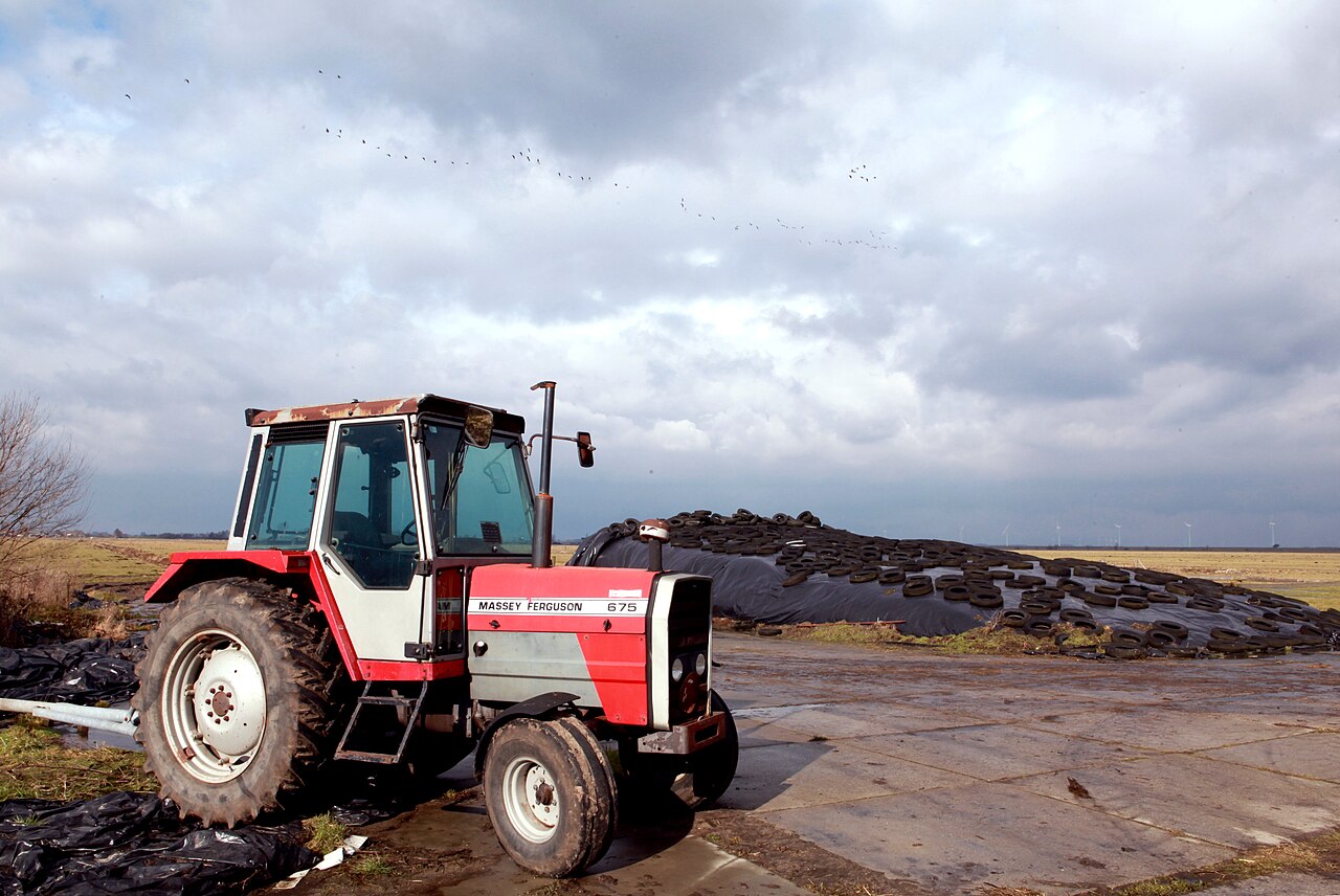 Massey Ferguson 675-traktor framför en ensilagehög; bilden visar inte växellådsutförandet.