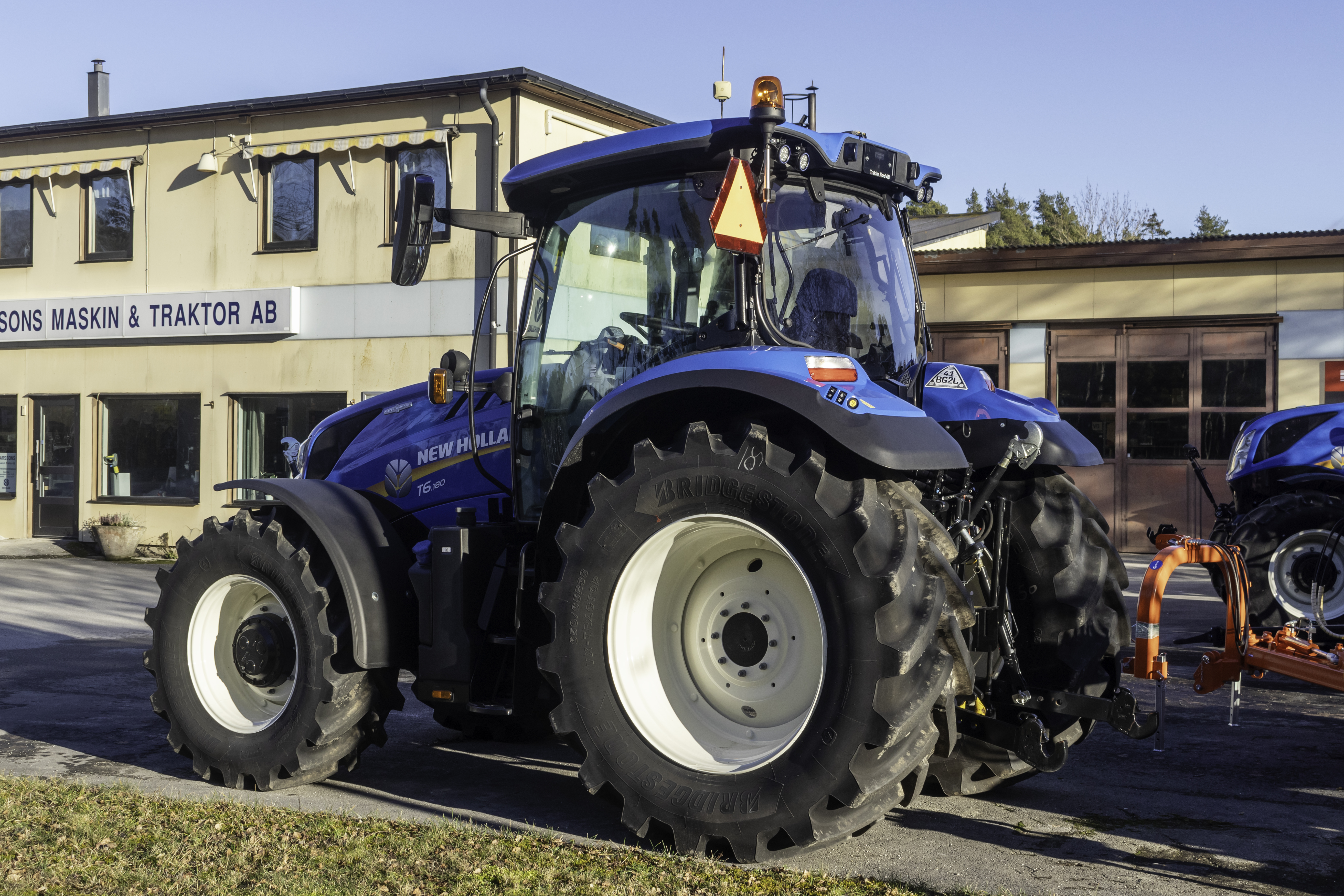 Blå New Holland T6.180 fotograferad på Gotland; transmissionen framgår inte.