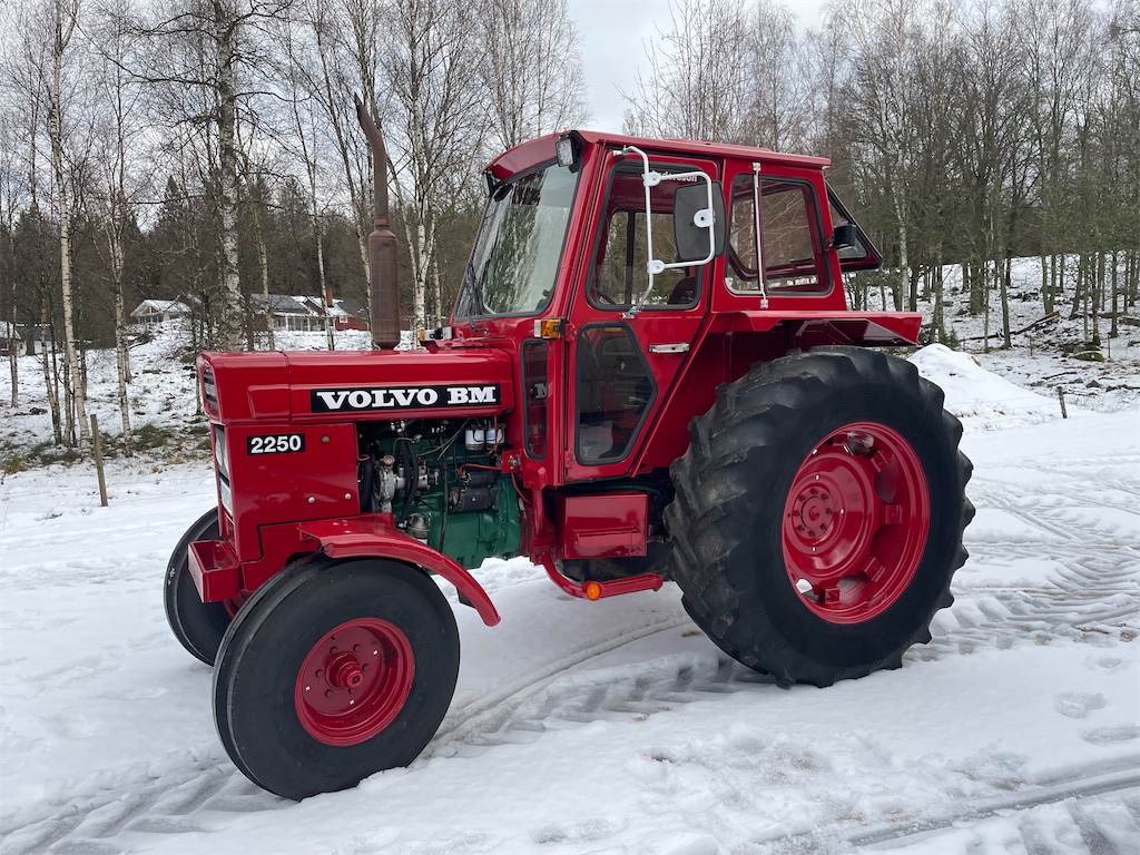 Röd Volvo BM 2250 från 1980 i snö; modellnumret 2250 syns på motorhuven.