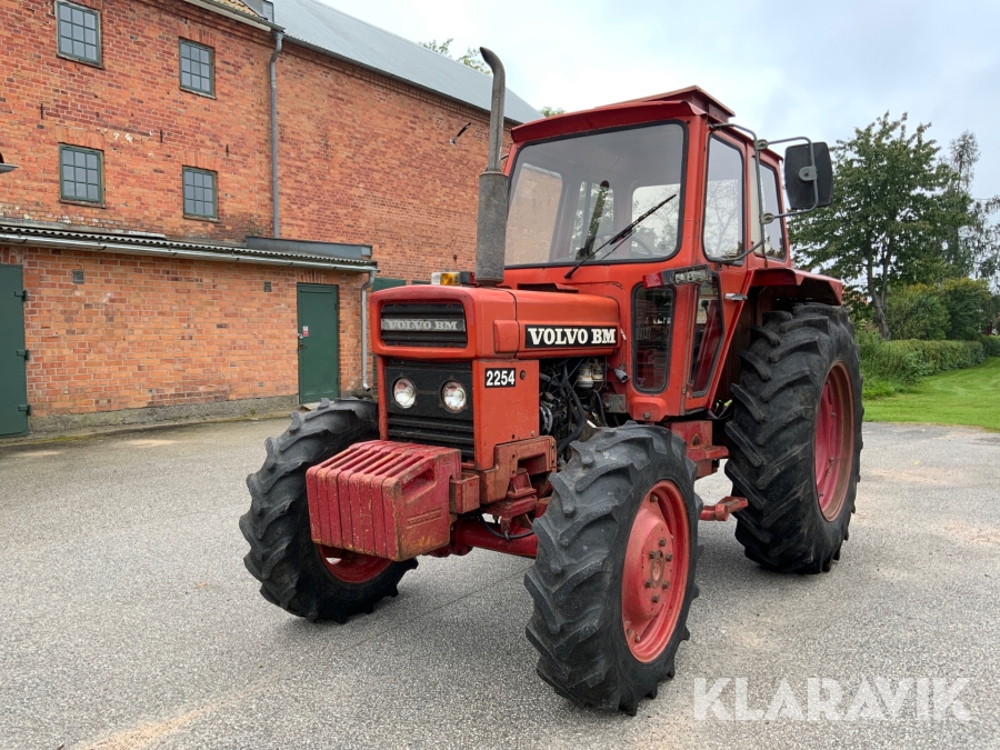Röd Volvo BM 2254 från 1981 sedd snett framifrån vid en tegelbyggnad; beteckningen 2254 syns på motorhuven.