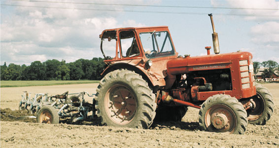 Röd BM Bison-traktor med jordbearbetningsredskap; källsidan grupperar 470/471.