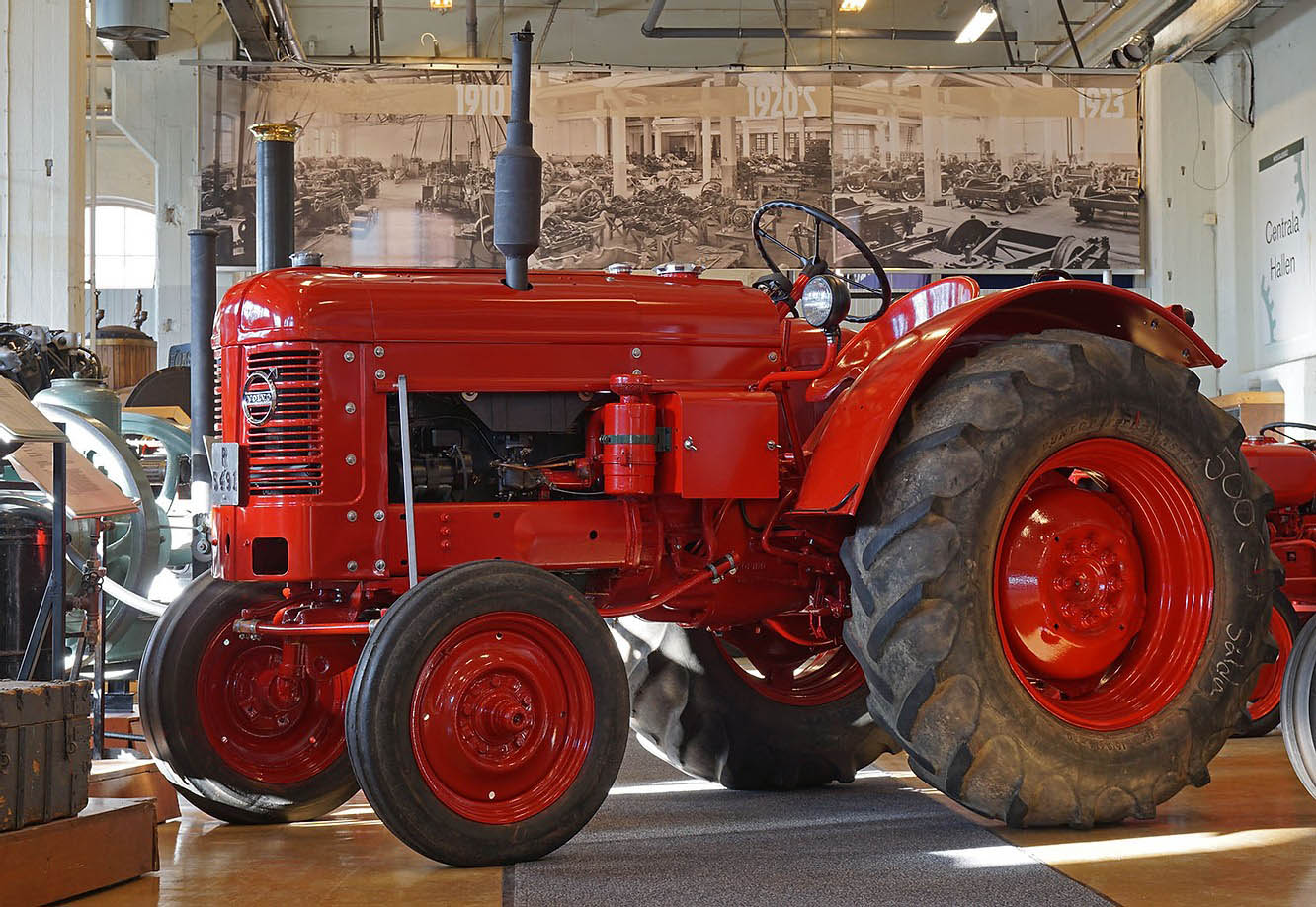 Röd Volvo-traktor sedd från sidan i en museihall, identifierad som T 31 av Munktellmuseets samlingspost.