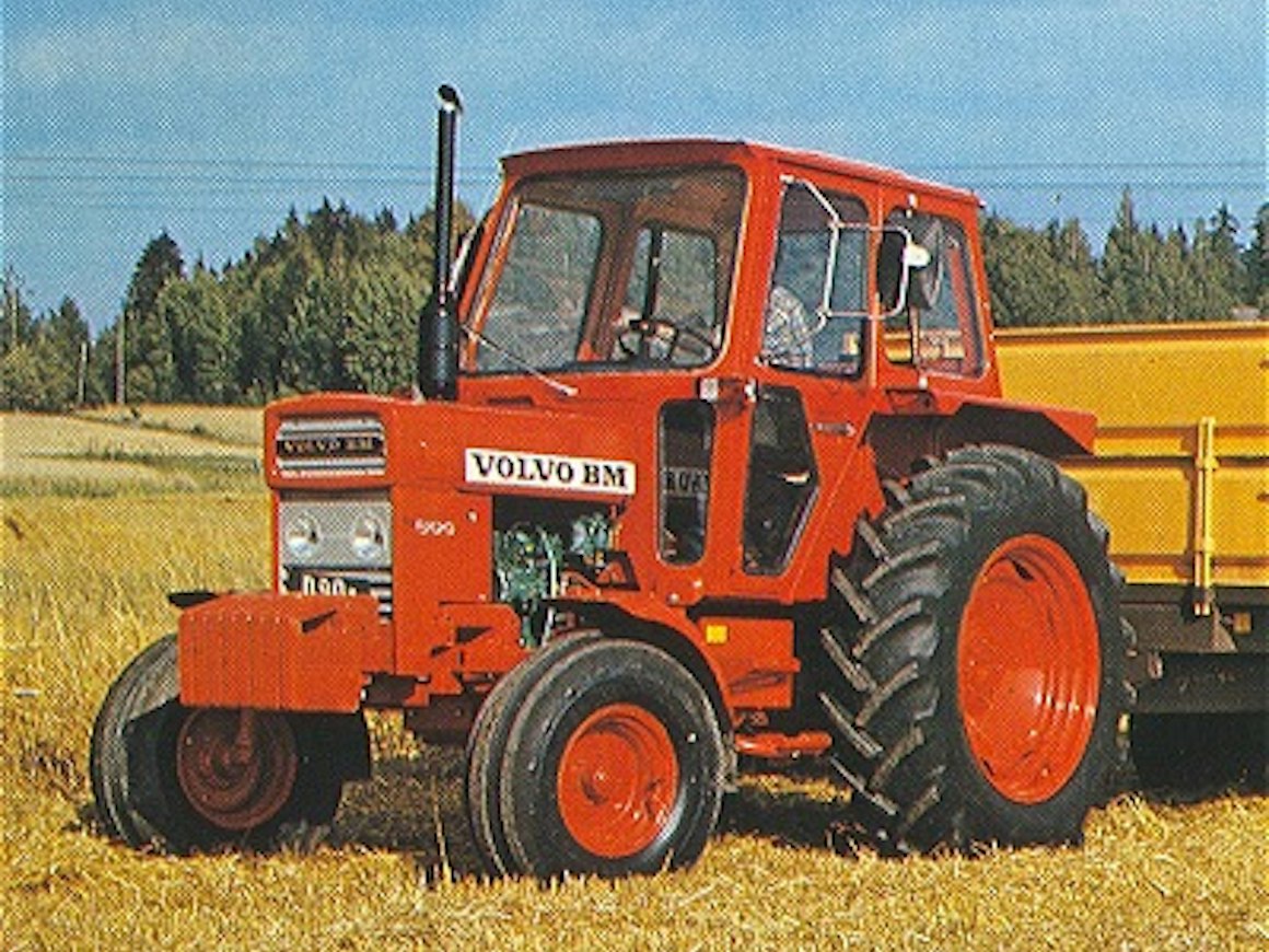 Röd Volvo BM T 500 med hytt och gul vagn på ett fält; bilden visar ett enskilt exemplar.